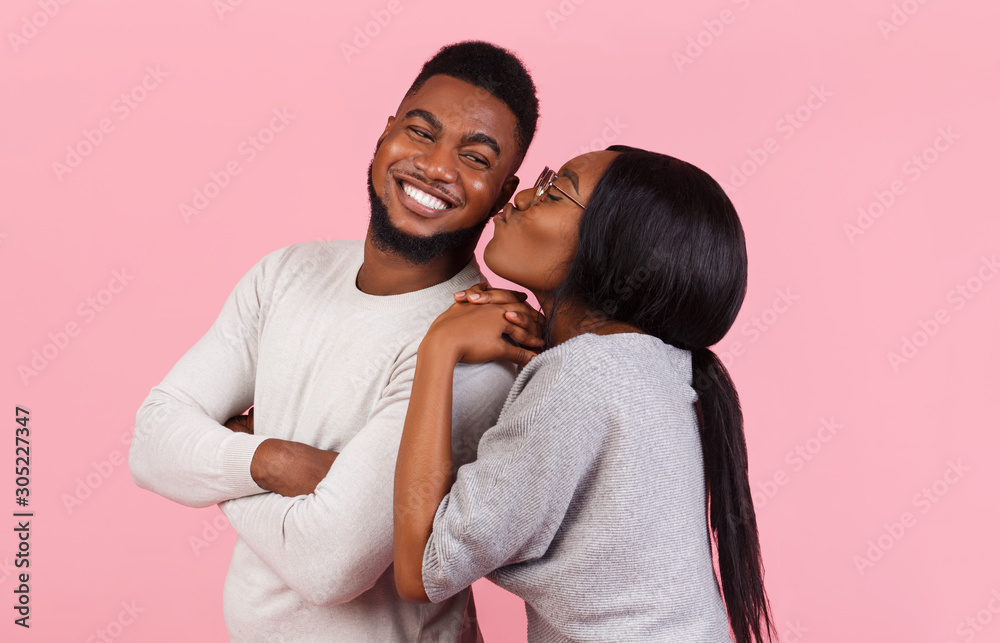 Obraz premium Happy african woman kissing her smiling man