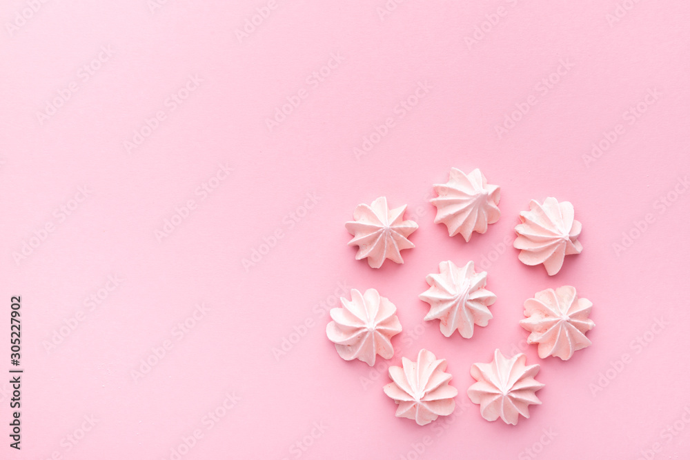 Composition of pink and white meringues on a pink paper background. Pastel.