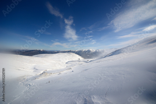 Winter snowy view in Caucasus mountains cold blue clear sky