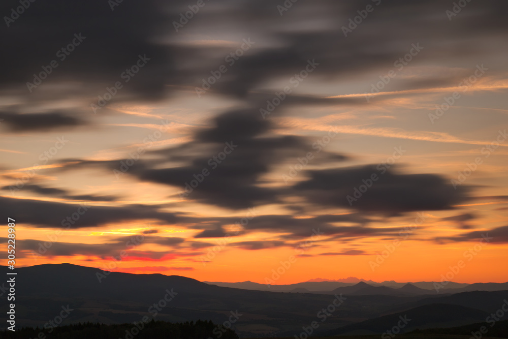 Red sunset with cloudy sky and mountains in the background Red sunset with cloudy sky and mountains in the background