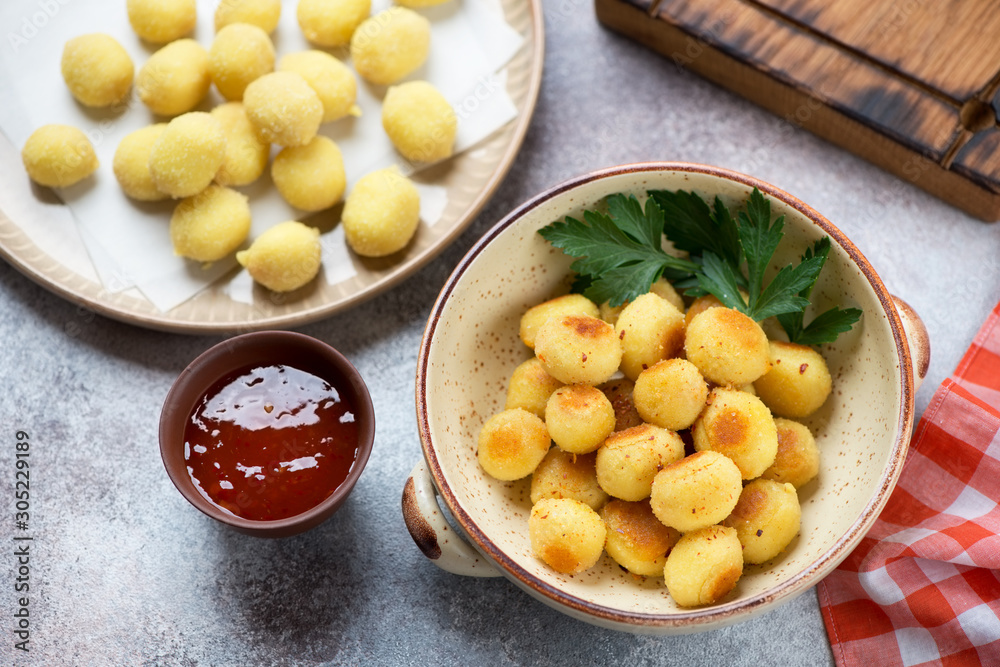Roasted and uncooked potato gnocchi, elevated view over beige stone background, horizontal shot Roasted and uncooked potato gnocchi, elevated view over beige stone background, horizontal shot