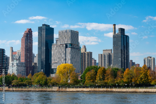 Shoreline of Roosevelt Island with the Midtown Manhattan Skyline in New York City with Colorful Trees during Autumn