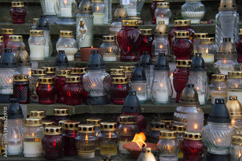 Monument and candles in the cemetery. All Saints Day in Poland. A lot of funeral candles. © Hanna Ohnivenko