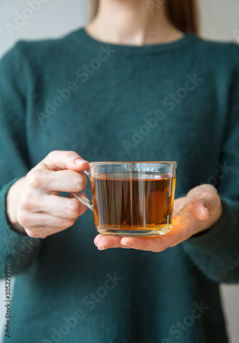 Transparent tea cup in woman's hand