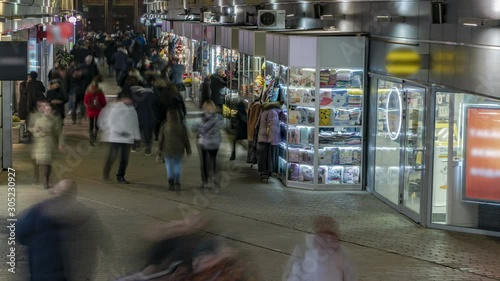 A crowd of people walking at the end of the day in the direction of the subway through the shopping arcade, time lapse