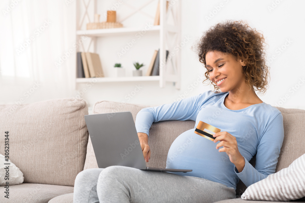 African pregnant mother ordering clothes for her baby, using laptop African pregnant mother ordering clothes for her baby, using laptop