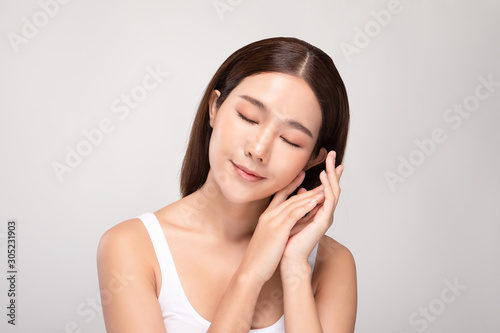Beautiful Asian young woman close her eyes touching soft cheek smile with clean and fresh skin Happiness and cheerful with positive emotional,isolated on white background,Beauty and Cosmetics Concept
