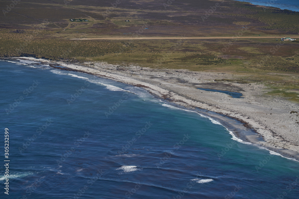 View from an aircraft flying over beautiful white sandy beaches and clear blue waters of Sea Lion Island in the Falkland Islands. View from an aircraft flying over beautiful white sandy beaches and clear blue waters of Sea Lion Island in the Falkland Islands.