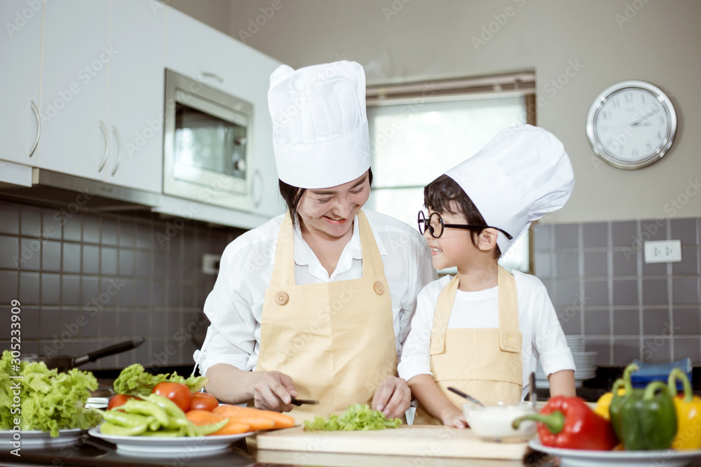 Happy family Asian woman young mother with son boy cooking healthy salad for the first time. first lesson and healthy lifestyle concept.