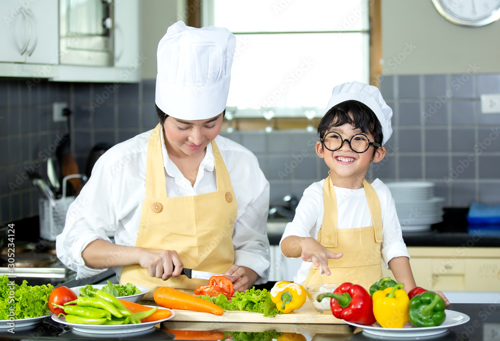 Happy family Asian woman young mother with son boy cooking healthy salad for the first time. first lesson and healthy lifestyle concept. Happy family Asian woman young mother with son boy cooking healthy salad for the first time. first lesson and healthy lifestyle concept.