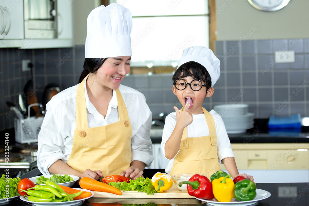 Happy family Asian woman young mother with son boy cooking healthy salad for the first time. first lesson and healthy lifestyle concept. Happy family Asian woman young mother with son boy cooking healthy salad for the first time. first lesson and healthy lifestyle concept.