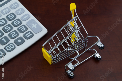 Smart shopping concept, shopping cart and calculator close up