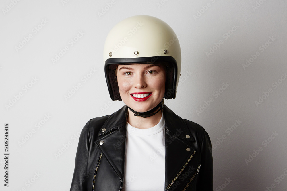 Young biker woman posing o the white background. Isolated. Young biker woman posing o the white background. Isolated.
