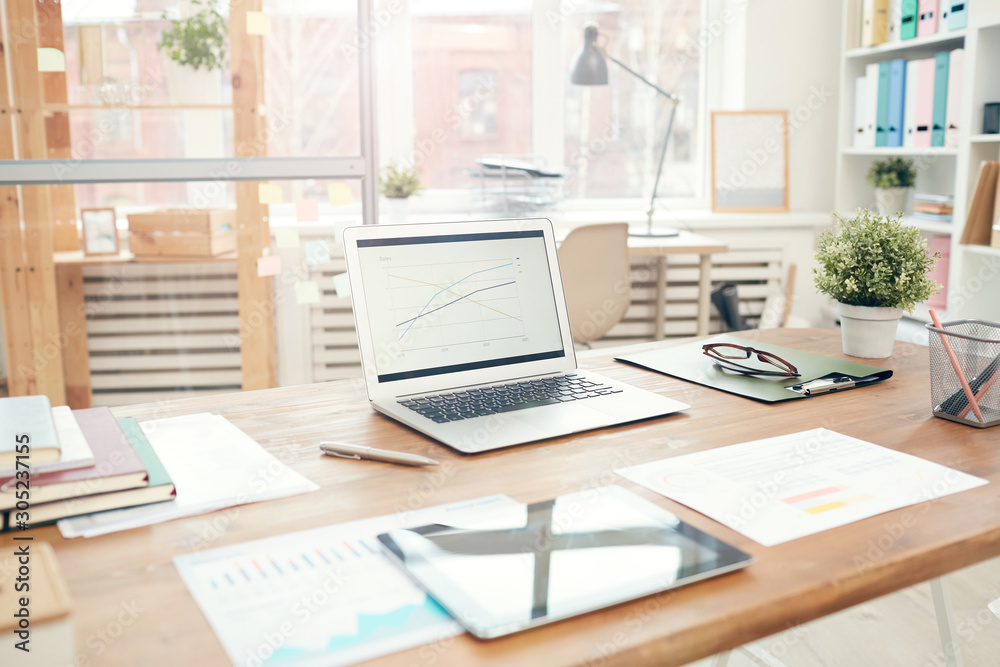 © Seventyfour - Background image of modern office interior with laptop on wooden table, workplace design concept, copy space © Seventyfour - Background image of modern office interior with laptop on wooden table, workplace design concept, copy space