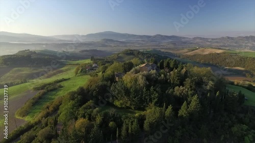 4k aerial  drone high fly footage over the Tuscany countryside hills and  the small ancien village of Gello near Volterra. photo