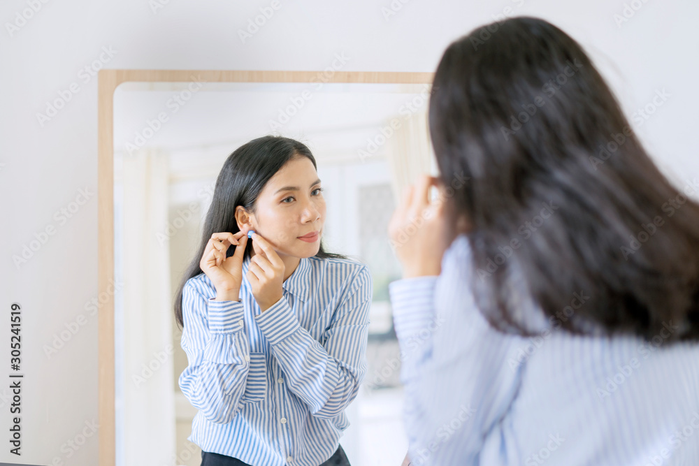 beautiful businesswoman putting on her earrings beautiful businesswoman putting on her earrings