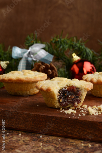 christmas mincemeat pie with bite on wood cutting board