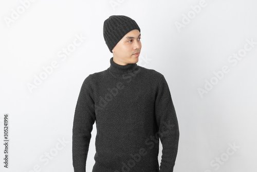 Young handsome asian man wearing grey sweater and beanie thinking an idea while looking up on white background.