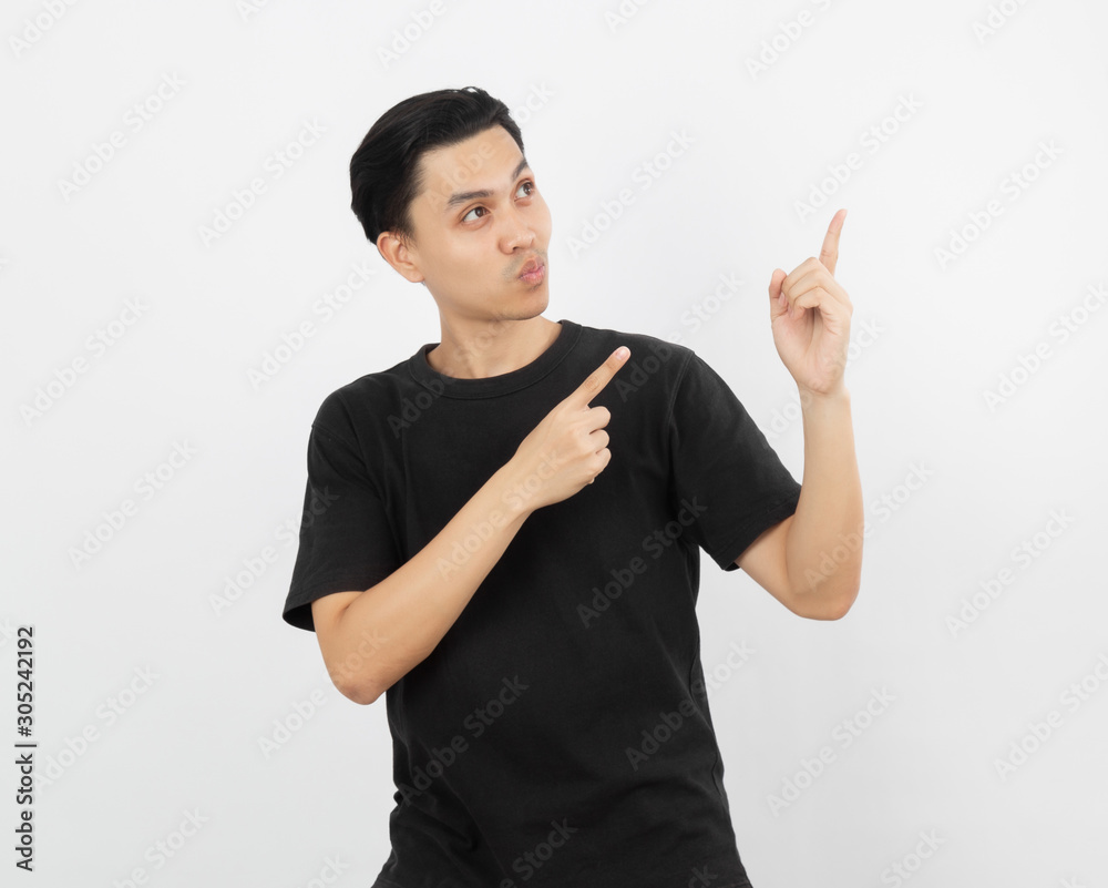 Young asian man with black shirt pointing to the side with a finger to present a product or an idea while looking forward surprising isolated on white background. Young asian man with black shirt pointing to the side with a finger to present a product or an idea while looking forward surprising isolated on white background.