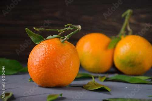  Bright orange mandarin with green leaves.