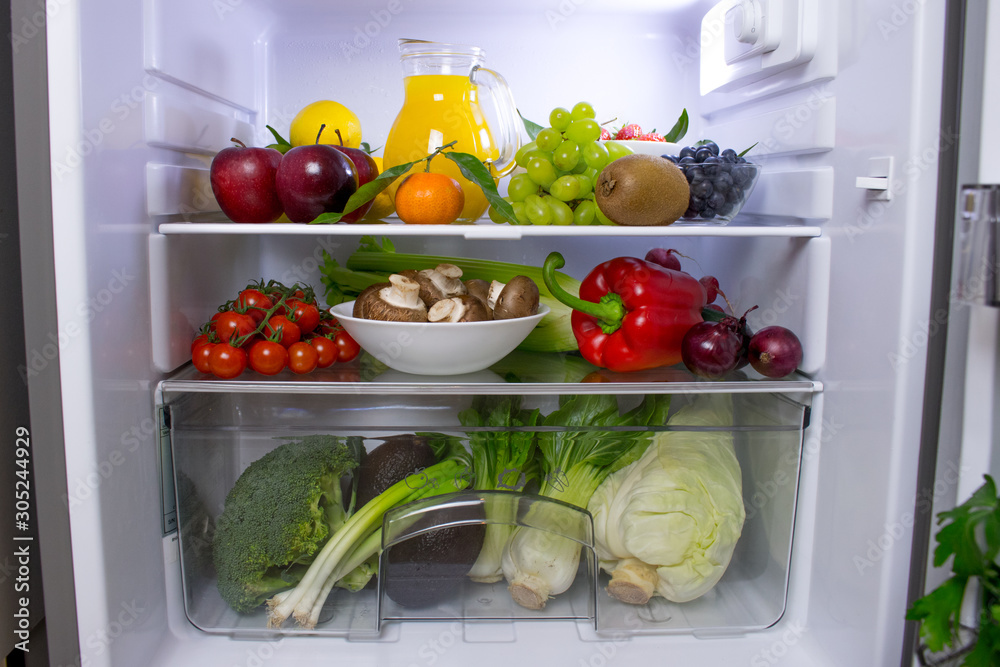 Food photography of a clean fridge filled with vegan foods such as fruits vegetables, juices and plant milk Food photography of a clean fridge filled with vegan foods such as fruits vegetables, juices and plant milk