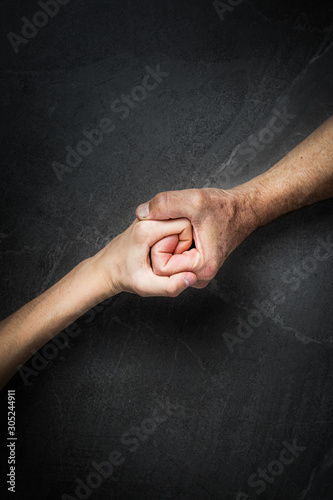 Adult hands holding kid hands