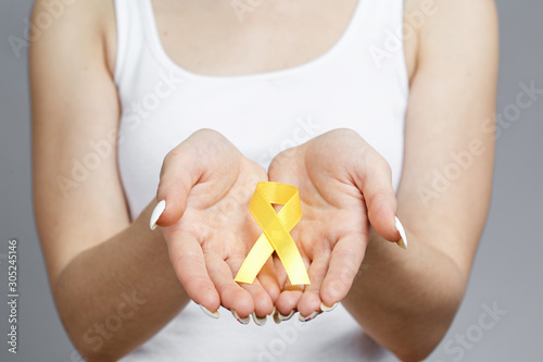 Girl with yellow or gold ribbon on gray background