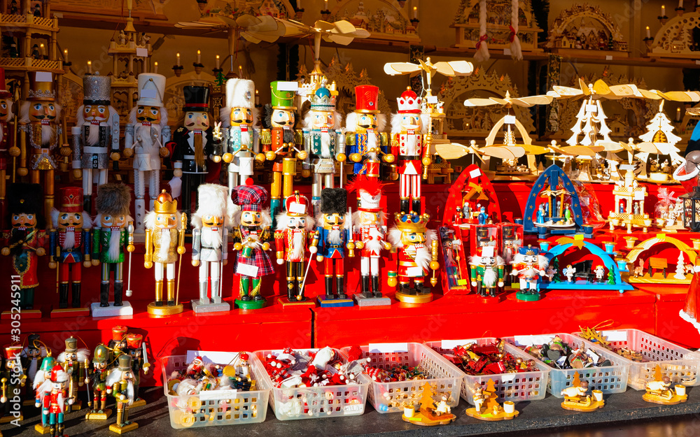 Obraz premium Wooden nutcrackers Christmas Tree Decorations on Christmas Market at Gendarmenmarkt in Winter Berlin, Germany. Wood nut crackers toys on Advent Fair, and Stalls with Crafts Items in Bazaar.