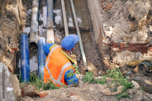 Obraz na płótnie municipal worker serves underground heating pipes
