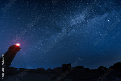 Men Ruz lighthouse under the milky way on the pink granit coast in Brittany photo