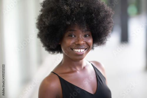 Gorgeous looking young black girl smiling broadly looking at the camera, dental service commercial