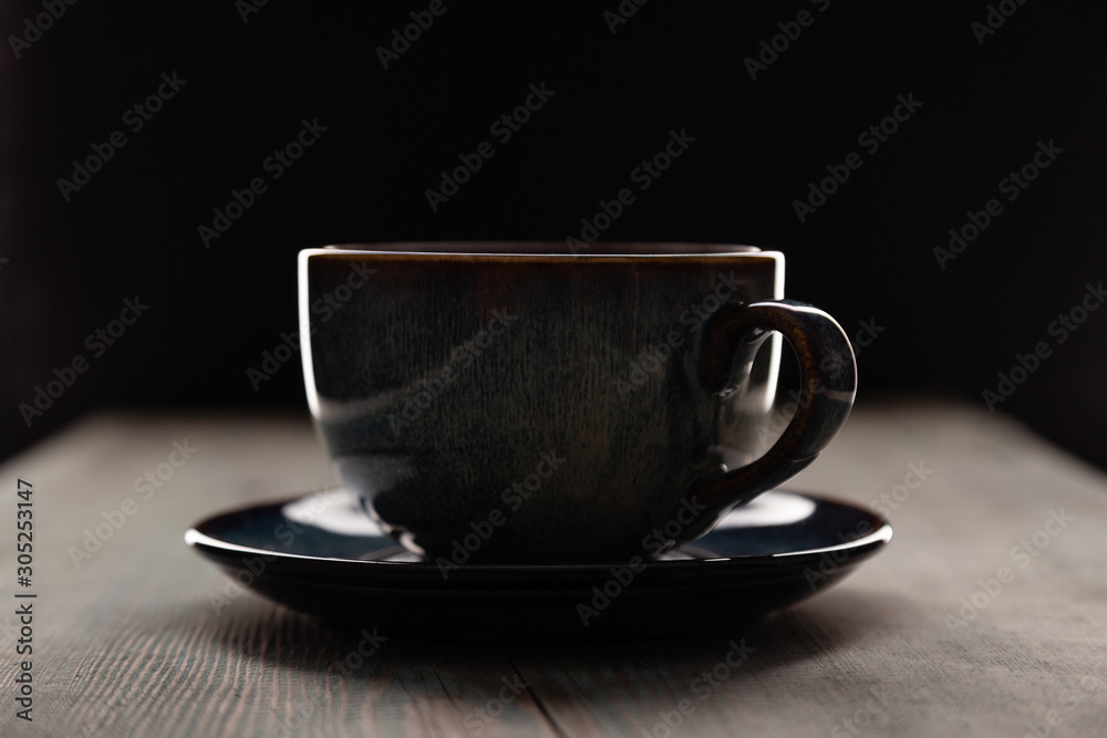 Latte or cappuccino in blue coffee cup side view closeup on dark background. Cafe bar, barista lifestyle art concept Latte or cappuccino in blue coffee cup side view closeup on dark background. Cafe bar, barista lifestyle art concept