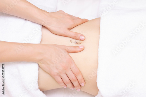 Massage Therapist Massaging a Womens Stomach. Massage and body care. Spa body massage woman hands treatment.