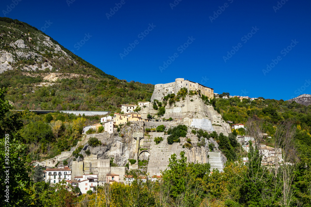 A view of the ancient village of Cerro al Volturno, surrounded by green woods and mountains. The Pandone castle stands on top of the hill, on a rock spur. Isernia, Molise, Italy.