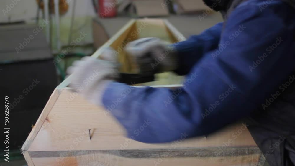 The carpenter works on a circular saw and an electric planer and makes blanks for the manufacture of coffins 19 The carpenter works on a circular saw and an electric planer and makes blanks for the manufacture of coffins 19