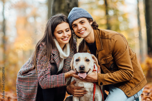 Romantic happy couple in love enjoying their time with pets in outumn park nature. photo