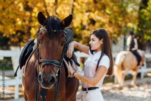 Girl rider ready for climbs a horse in the forest. Equestrian sport concept.