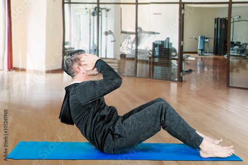 Man doing sit-up exercise at gym