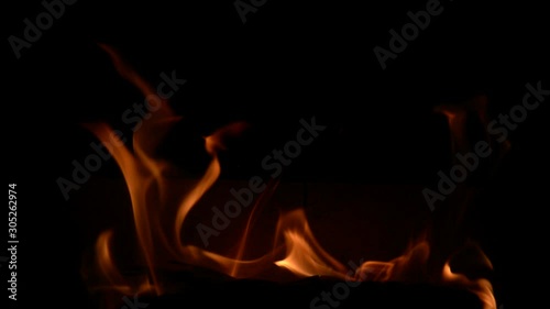 Playful flames flicker in the fireplace, close up