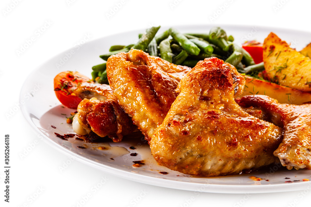 Fried chicken wings with baked potatoes and vegetable salad Fried chicken wings with baked potatoes and vegetable salad
