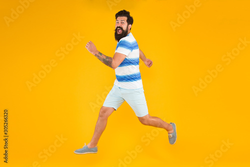 time to relax. active runner in move. Hurry up. Summer vacation. Man bearded hipster run yellow wall. Guy beard striped shirt. Freedom jump. Sale and discount. rush hour. lets go seasonal shopping © be free