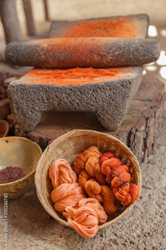 Dyed Yarn in The Basket And Mealing Stone With Orange Powder photo