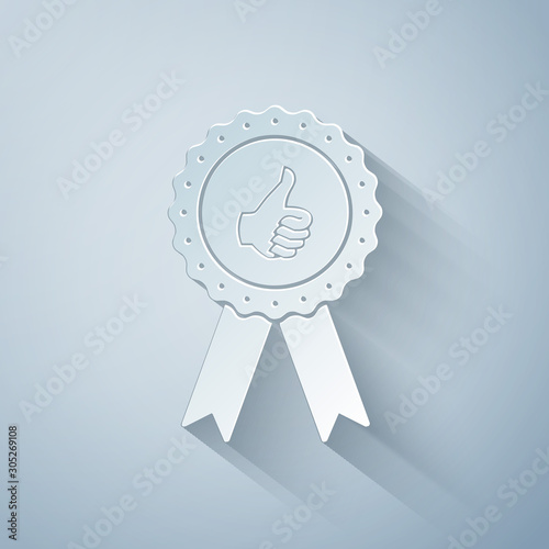 Paper cut Thumbs up on medal badge with ribbons icon isolated on grey background. Paper art style. Vector Illustration
