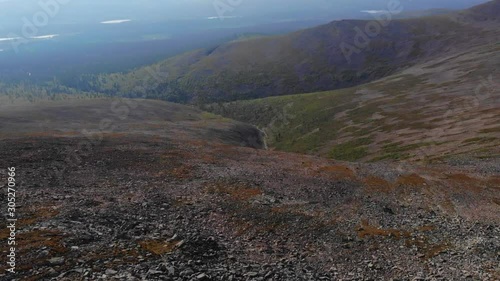 Aerial, tilt down, drone shot, the rocky summit of the Sokosti fell, revealing arctic nature and boreal wilderness, of the Urho Kekkonen national park, on a sunny, summer day, in Lapland, Finland photo