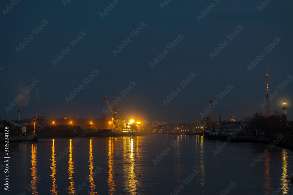 in the evening, ship lights shine in the port