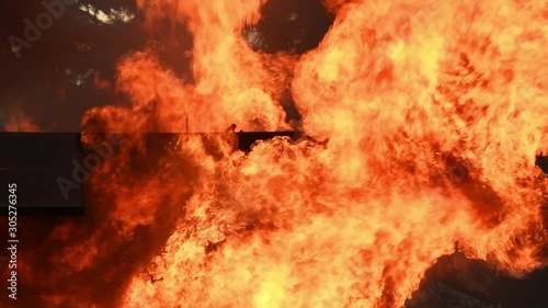 Big real fire of gas and oil explosion bursting through air.The building was burnt down.infernal fire in an industrial factory with big flame and smoke. Looping Fire Flames. Fire wall in slow motion.