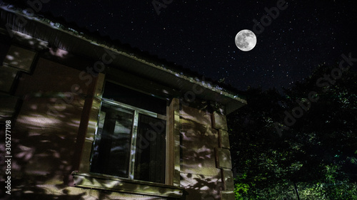 Fototapeta Naklejka Na Ścianę i Meble -  Vintage country house at night with clouds and stars. Cold autumn night