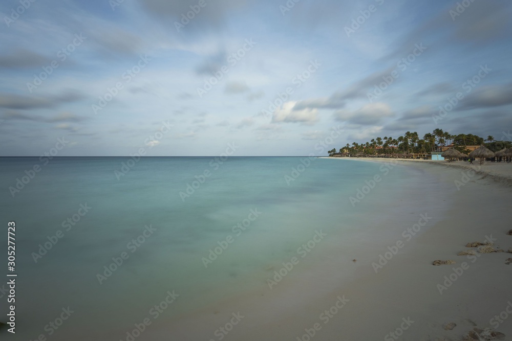 White sand beach and turquoise waves. Turquoise sea water and blue sky. Eagle Beach of Aruba Island. Beautiful backgrounds. White sand beach and turquoise waves. Turquoise sea water and blue sky. Eagle Beach of Aruba Island. Beautiful backgrounds.