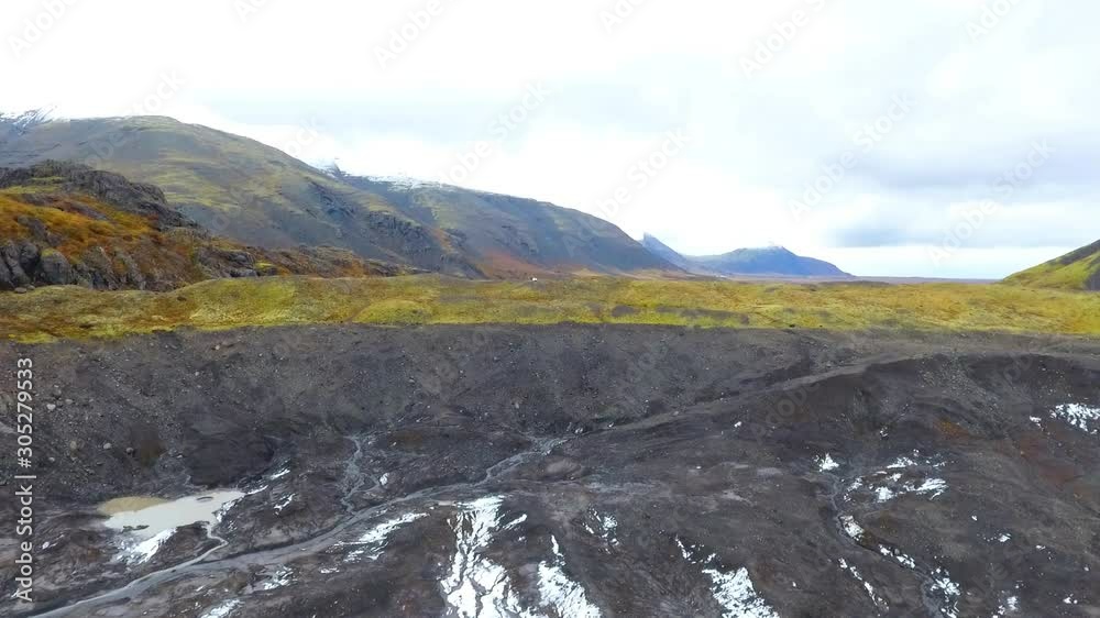 Aerial top view of the ridges of white glacier with black ash. Scenic iceberg in national park in Iceland. Aerial top view of the ridges of white glacier with black ash. Scenic iceberg in national park in Iceland.