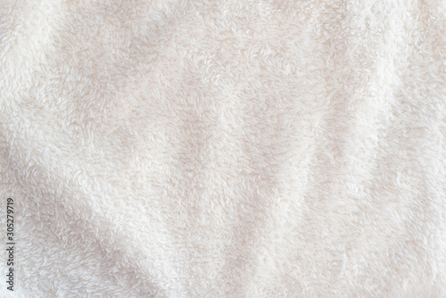 A soft cozy plaid made of white fabric with pile lies in beautiful folds